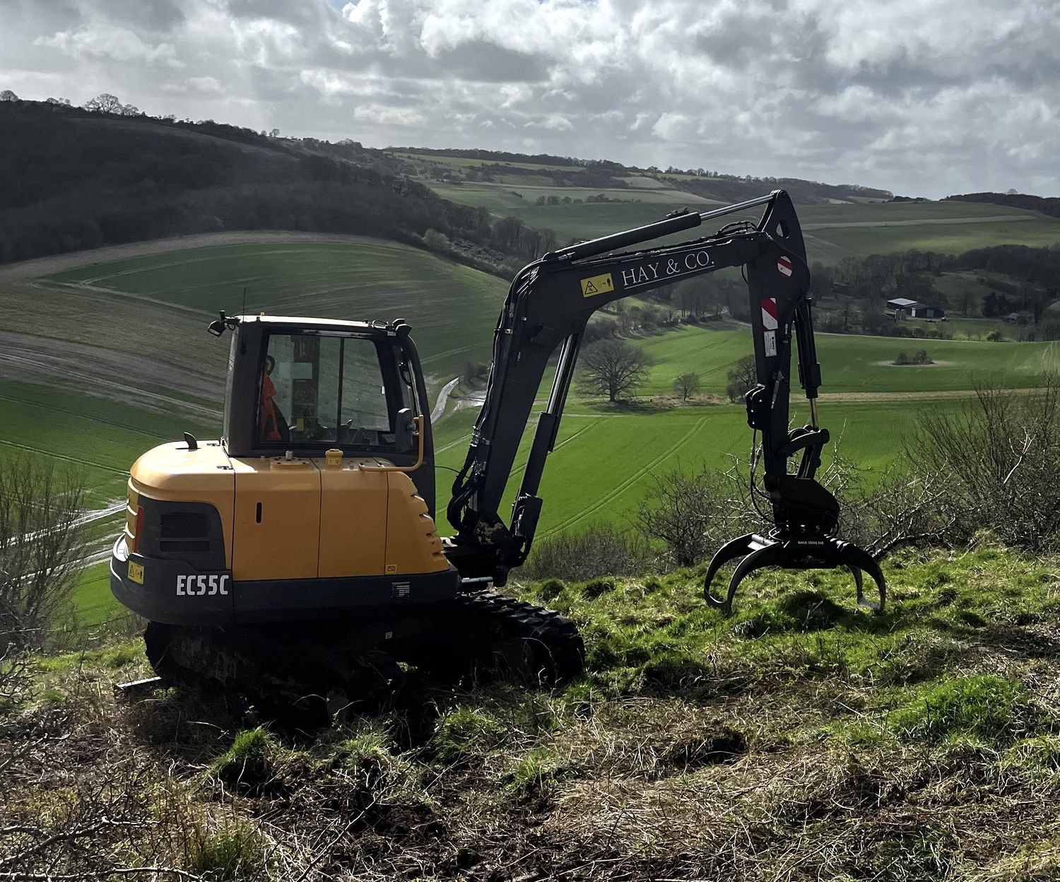 Volvo EC55C 6-tonne excavator fitted with a selector grab on a downland clearance job