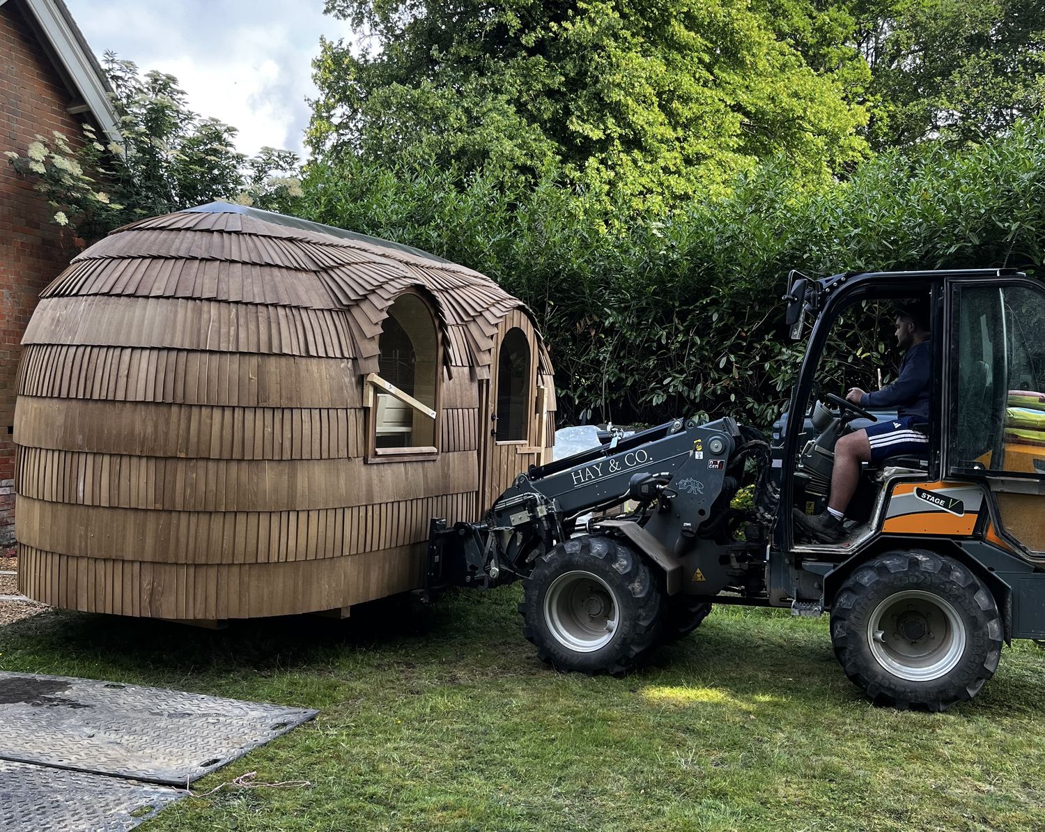 Giant G2700 HD+ telehandler placing a timber garden building into position on a lawn